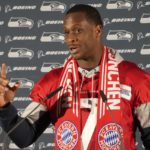 
              Seattle Seahawks quarterback Geno Smith wears a FC Bayern Munich scarf as he answers questions during a news conference after a practice session in Munich, Germany, Thursday, Nov. 10, 2022. The Tampa Bay Buccaneers are set to play the Seattle Seahawks in an NFL game at the Allianz Arena in Munich on Sunday. (AP Photo/Matthias Schrader)
            