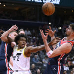 
              Utah Jazz guard Collin Sexton (2) competes for the ball against Washington Wizards forward Deni Avdija, right, and center Kristaps Porzingis, left, during the first half of an NBA basketball game Saturday, Nov. 12, 2022, in Washington. (AP Photo/Nick Wass)
            