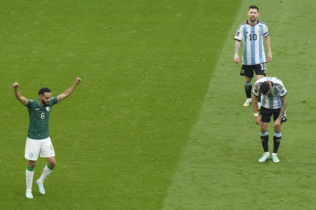 Argentina's Lionel Messi, top right, leaves the pitch as Saudi Arabia's Mohammed Al-Burayk celebrat...