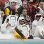 
              Spectators hold photos of Forman German international Mesut Ozil on the stands during the World Cup group E soccer match between Spain and Germany, at the Al Bayt Stadium in Al Khor , Qatar, Sunday, Nov. 27, 2022. (AP Photo/Matthias Schrader)
            