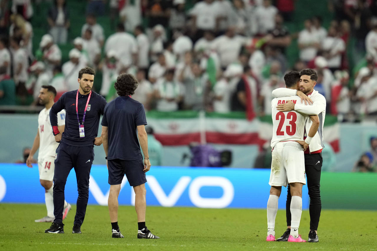 Iran's Ramin Rezaeian (23) is consoled after losing 1-0 to the United States in a World Cup group B...
