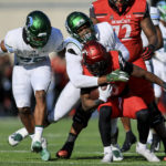 
              Cincinnati running back Charles McClelland, front, carries the ball as he is tackled by Tulane linebacker Keith Cooper Jr., back, while linebacker Jesus Machado, left, supports during the second half of an NCAA college football game, Friday, Nov. 25, 2022, in Cincinnati. (AP Photo/Aaron Doster)
            