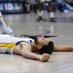 
              Golden State Warriors guard Stephen Curry lays on the ground after being fouled taking a shot in the second half of an NBA basketball game against the Dallas Mavericks in Dallas, Tuesday, Nov. 29, 2022. (AP Photo/Tony Gutierrez)
            