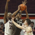
              Lehigh's Jakob Alamudun, center, is guarded by Virginia Tech's Justyn Mutts (25) and Hunter Cattoor (0) during the first half of an NCAA college basketball game Thursday, Nov. 10, 2022, in Blacksburg, Va. (Matt Gentry/The Roanoke Times via AP)
            