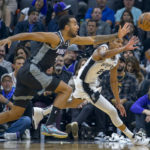 
              Sacramento Kings forward Trey Lyles (41) and San Antonio Spurs guard Devin Vassell (24) chase the ball during the first quarter of an NBA basketball game in Sacramento, Calif., Thursday, Nov. 17, 2022. (AP Photo/Randall Benton)
            