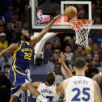 
              Golden State Warriors forward Andrew Wiggins (22) dunks over Minnesota Timberwolves center Rudy Gobert (27) during the first quarter of an NBA basketball game Sunday, Nov. 27, 2022, in Minneapolis. (AP Photo/Andy Clayton-King)
            