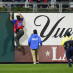 
              A fan climbs down to the field during the sixth inning in Game 5 of baseball's World Series between the Houston Astros and the Philadelphia Phillies on Thursday, Nov. 3, 2022, in Philadelphia. (AP Photo/Matt Slocum)
            