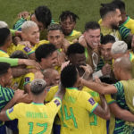 
              Brazil's Casemiro, covered by his teammates, celebrates after scoring his side's opening goal during the World Cup group G soccer match between Brazil and Switzerland, at the Stadium 974 in Doha, Qatar, Monday, Nov. 28, 2022. (AP Photo/Thanassis Stavrakis)
            