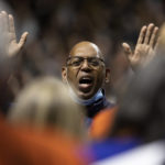 
              The director of the MLK Community Choir leads the group in song during a memorial service in Charlottesville, Va., Saturday, Nov. 19, 2022. Over a thousand students and locals attended the service at John Paul Jones Arena to honor three student football players who were killed on Sunday, Nov. 13, 2022. (Mike Kropf/The Daily Progress via AP)
            