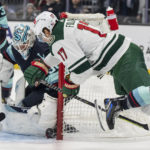 
              Seattle Kraken goalie Martin Jones, left, keeps the puck out of the goal, next to Minnesota Wild forward Marcus Foligno during the first period of an NHL hockey game Friday, Nov. 11, 2022, in Seattle. (AP Photo/Stephen Brashear)
            