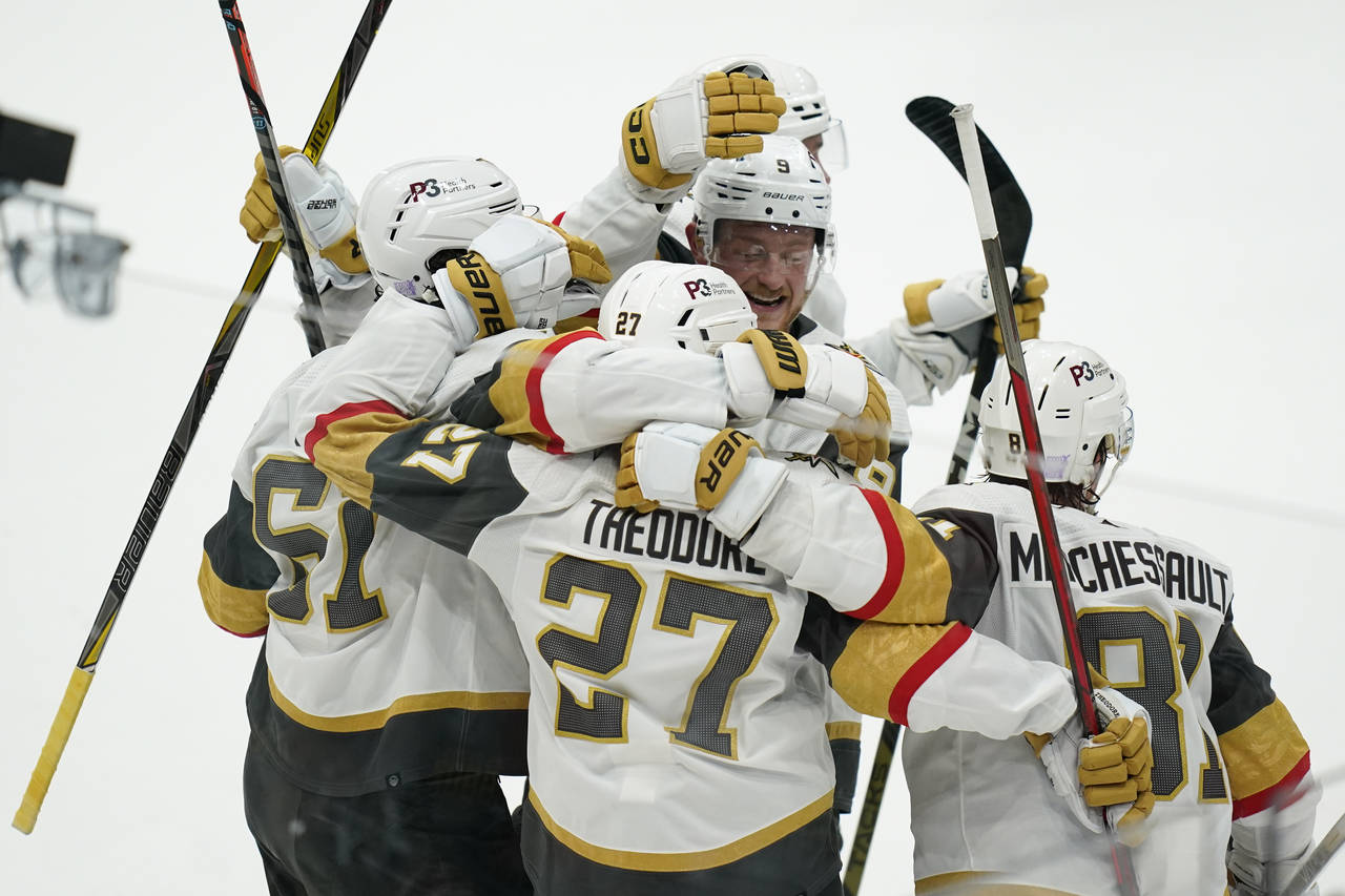 Vegas Golden Knights' Shea Theodore (27) celebrates his goal with teammates during overtime in an N...