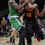 
              Atlanta Hawks forward De'Andre Hunter (12) is fouled by Boston Celtics guard Jaylen Brown (7) as he drives to the basket during the first half of an NBA basketball game Wednesday, Nov. 16, 2022 in Atlanta. (AP Photo/John Bazemore)
            