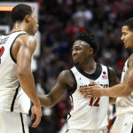 
              San Diego State forward Jaedon LeDee (13), Darrion Trammell (12) and Matt Bradley celebrate during the second half of the team's NCAA college basketball game against BYU on Friday, Nov. 11, 2022, in San Diego. (AP Photo/Denis Poroy)
            