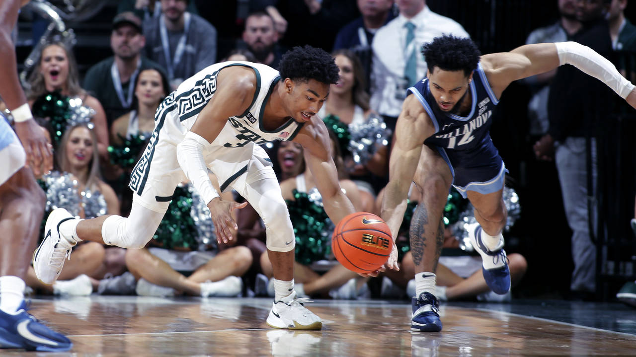 Michigan State's Jaden Akins, left, steals the ball from Villanova's Caleb Daniels during the secon...