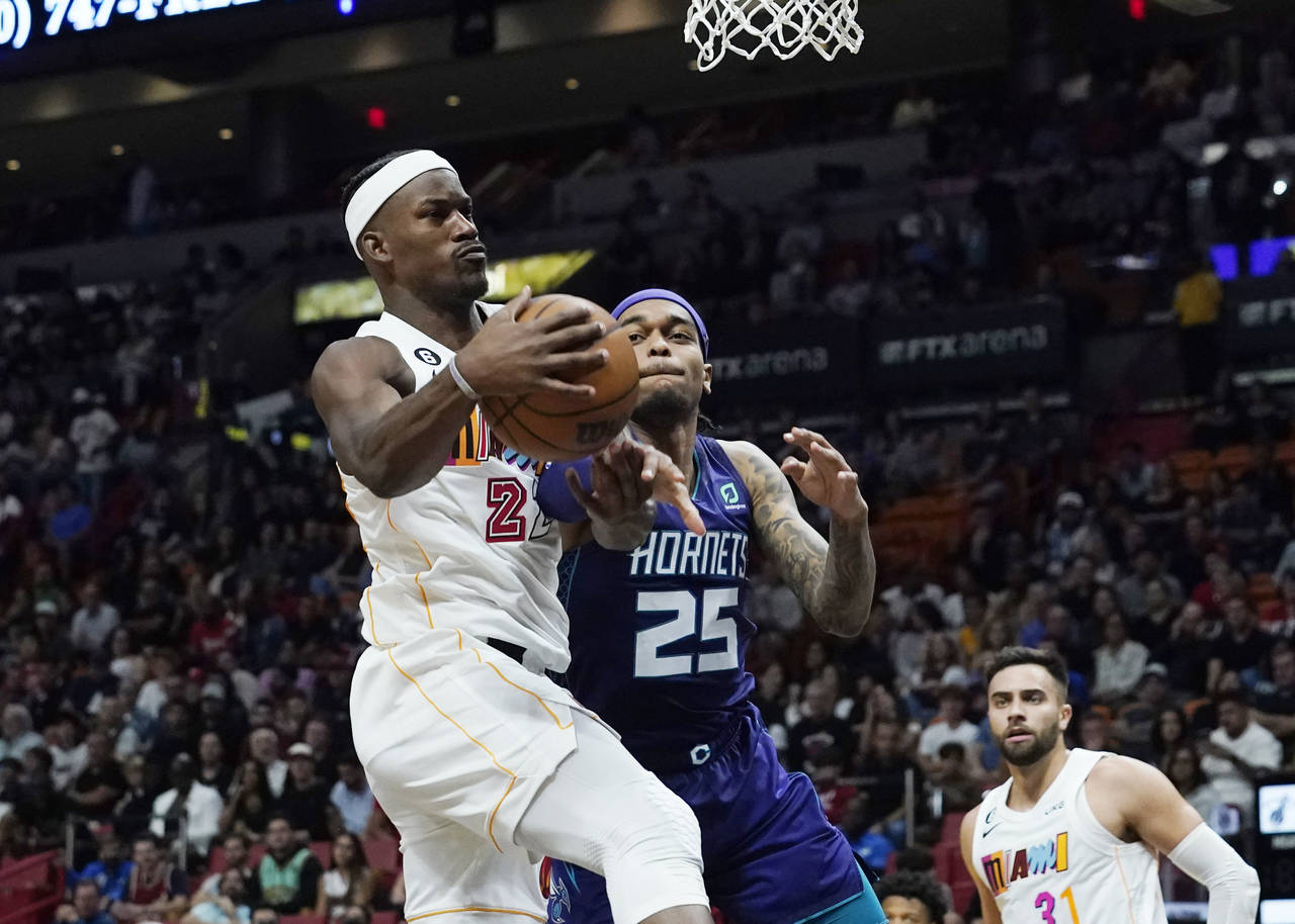 Miami Heat forward Jimmy Butler (22) grabs a rebound from Charlotte Hornets forward P.J. Washington...
