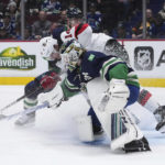 
              Vancouver Canucks goalie Thatcher Demko (35) makes a save as Tanner Pearson (70) checks New Jersey Devils' Nathan Bastian (14)during the third period of an NHL hockey game Tuesday, Nov. 1, 2022, in Vancouver, British Columbia. (Darryl Dyck/The Canadian Press via AP)
            
