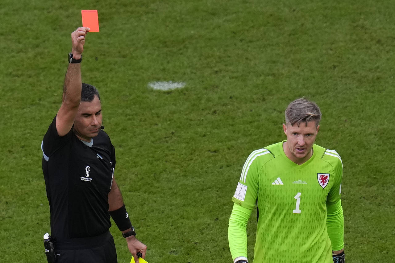 Referee Mario Alberto Escobar Toca shows a red card to Wales' goalkeeper Wayne Hennessey during the...