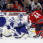 
              Carolina Hurricanes' Calvin de Haan (44) controls the puck in front of Toronto Maple Leafs goaltender Erik Kallgren (50) with Maple Leafs' Mitchell Marner (16) nearby during the first period of an NHL hockey game in Raleigh, N.C., Sunday, Nov. 6, 2022. (AP Photo/Karl B DeBlaker)
            