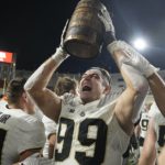 
              Purdue's Jack Sullivan (99) celebrates with the Old Oaken Bucket after Purdue defeated Indiana in an NCAA college football game, Saturday, Nov. 26, 2022, in Bloomington, Ind. (AP Photo/Darron Cummings)
            
