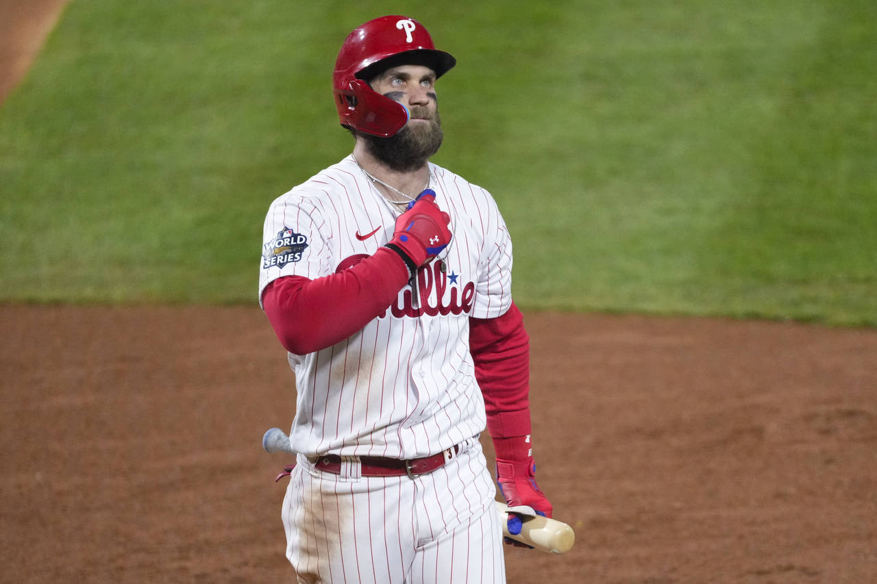 Philadelphia Phillies' Bryce Harper walks to the dugout after striking out during the fourth inning...