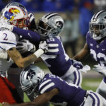 
              Kansas wide receiver Lawrence Arnold (2) is stopped by Kansas State safety VJ Payne (19), linebacker Daniel Green (22) and safety Drake Cheatum (21) after catching a pass for a first down during the first quarter of an NCAA college football game Saturday, Nov. 26, 2022, in Manhattan, Kan. (AP Photo/Colin E. Braley)
            