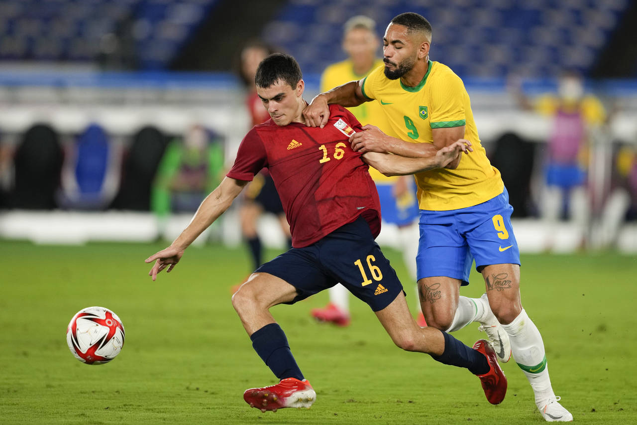 FILE - Spain's Pedri Gonzalez, left, and Brazil's Matheus Cunha battle for the ball during the men'...