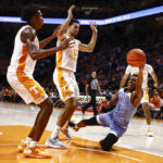 
              McNeese State guard Trae English (1) passes the ball off as he's defended by Tennessee forward Olivier Nkamhoua (13) and forward Julian Phillips during the first half of an NCAA college basketball game Wednesday, Nov. 30, 2022, in Knoxville, Tenn. (AP Photo/Wade Payne)
            