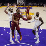 
              Cleveland Cavaliers guard Donovan Mitchell (45) drives past Los Angeles Lakers forward Anthony Davis, left, and forward LeBron James during the first half of an NBA basketball game Sunday, Nov. 6, 2022, in Los Angeles. (AP Photo/Marcio Jose Sanchez)
            