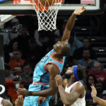 
              Phoenix Suns center Bismack Biyombo, left, scores against New York Knicks center Mitchell Robinson, right, during the first half of an NBA basketball game in Phoenix, Sunday, Nov. 20, 2022. (AP Photo/Ross D. Franklin)
            