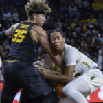 
              Wichita State's Shaman Scott, right, has the ball as Missouri's Nick Honor, middle, and Noah Carter defend during the first half of an NCAA college basketball game Tuesday, Nov. 29, 2022, in Wichita, Kan. (Travis Heying/The Wichita Eagle via AP)
            