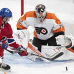 
              Montreal Canadiens' Sean Monahan (91) moves in on Philadelphia Flyers goaltender Carter Hart during the second period of an NHL hockey game Saturday, Nov. 19, 2022, in Montreal. (Graham Hughes/The Canadian Press via AP)
            
