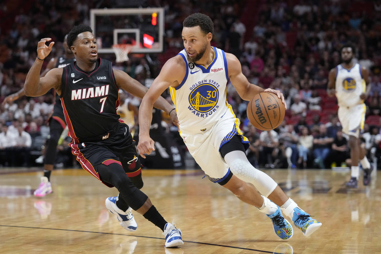 Golden State Warriors guard Stephen Curry (30) drives to the basket past Miami Heat guard Kyle Lowr...