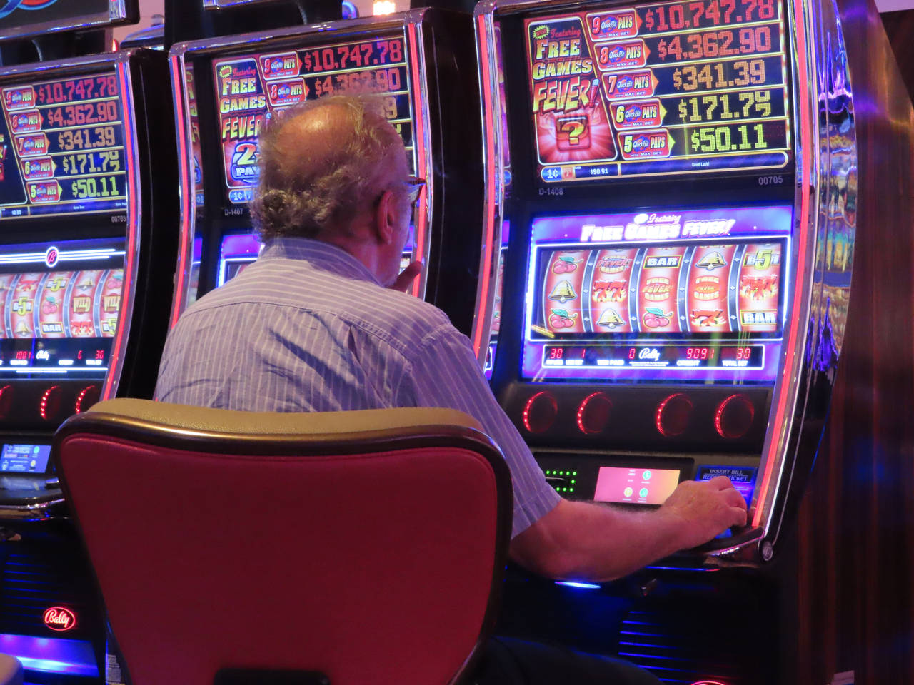 A gambler plays a slot machine at the Hard Rock Casino in Atlantic City, N.J., on Aug. 8, 2022. Fig...