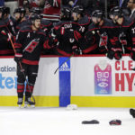 
              A member of the ice crew picks up hats thrown onto the ice as Carolina Hurricanes center Sebastian Aho (20) celebrates with teammates after his third goal of the night, during the third period of an NHL hockey game against the Buffalo Sabres on Friday, Nov. 4, 2022, in Raleigh, N.C. (AP Photo/Chris Seward)
            