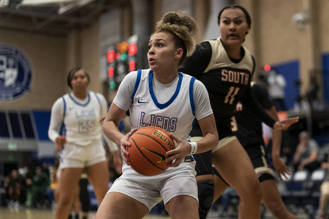La Jolla Country Day high school point guard Jada Williams, center, drives to the basket during a b...