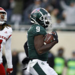 
              Michigan State's Daniel Barker, right, scores on a pass reception against Rutgers' Desmond Igbinosun (4) during the first half of an NCAA college football game, Saturday, Nov. 12, 2022, in East Lansing, Mich. (AP Photo/Al Goldis)
            