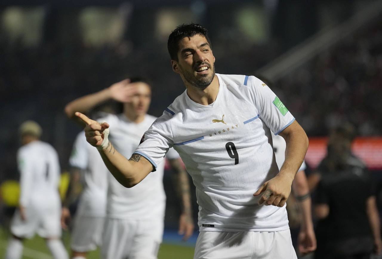 FILE - Uruguay's Luis Suarez celebrates scoring his side's opening goal against Paraguay during a q...