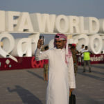 
              FILE - A man takes a selfie with a sign reading in English" Fifa World Cup, Qatar 2022" at the corniche in Doha, Qatar, Friday, Nov. 11, 2022. With no soccer tradition but billions in oil money, Qatar is the latest Persian Gulf nation using sports to try to burnish its image on the global stage. The host of the 2022 World Cup is smaller than Connecticut and has a population of fewer than 3 million. (AP Photo/Hassan Ammar, File)
            