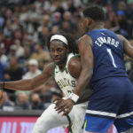 
              Milwaukee Bucks guard Jrue Holiday, left, works toward the basket while defended by Minnesota Timberwolves guard Anthony Edwards (1) during the first half of an NBA basketball game, Friday, Nov. 4, 2022, in Minneapolis. (AP Photo/Abbie Parr)
            
