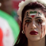 
              A woman stands on the tribune with her face painted in memory of Mahsa Amini, a woman who died while in police custody in Iran at the age of 22, prior to the World Cup group B soccer match between Wales and Iran, at the Ahmad Bin Ali Stadium in Al Rayyan , Qatar, Friday, Nov. 25, 2022. (AP Photo/Frank Augstein)
            