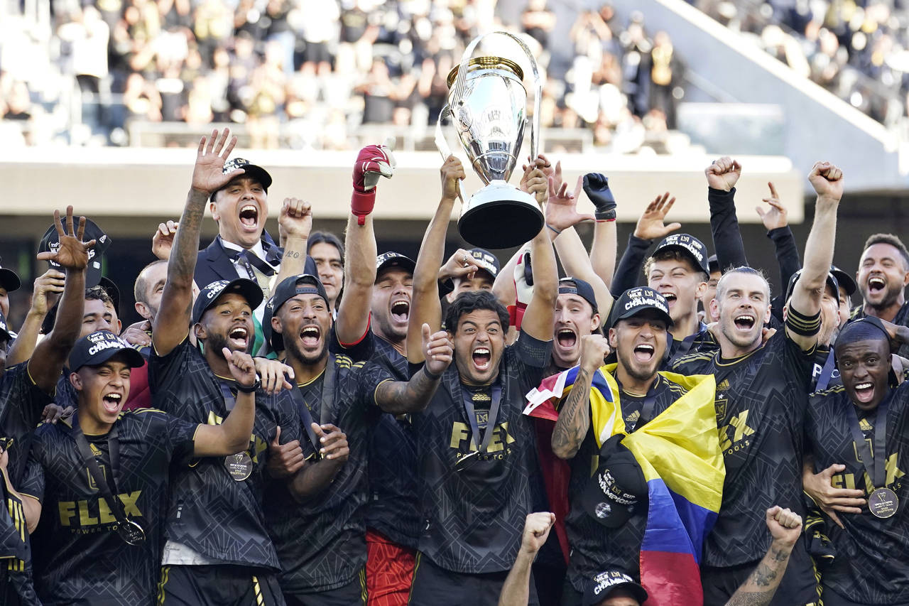 Los Angeles FC's Carlos Vela hoists the trophy alongside teammates after defeating the Philadelphia...