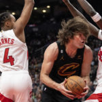 
              Cleveland Cavaliers' Robin Lopez, center, drives between Toronto Raptors' Scottie Barnes (4) and Chris Boucher, right, during second-half NBA basketball game action in Toronto, Monday, Nov. 28, 2022. (Chris Young/The Canadian Press via AP)
            