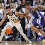 
              Butler guard Pierce Thomas (14) is fouled by Kansas State forward Keyontae Johnson (11) as they go for a loose ball in the first half of an NCAA college basketball game in Indianapolis, Wednesday, Nov. 30, 2022. (AP Photo/Michael Conroy)
            