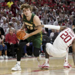 
              North Dakota State forward Andrew Morgan (23) drives past Arkansas forward Kamani Johnson (20) during the first half of an NCAA college basketball game Monday, Nov. 7, 2022, in Fayetteville, Ark. (AP Photo/Michael Woods)
            