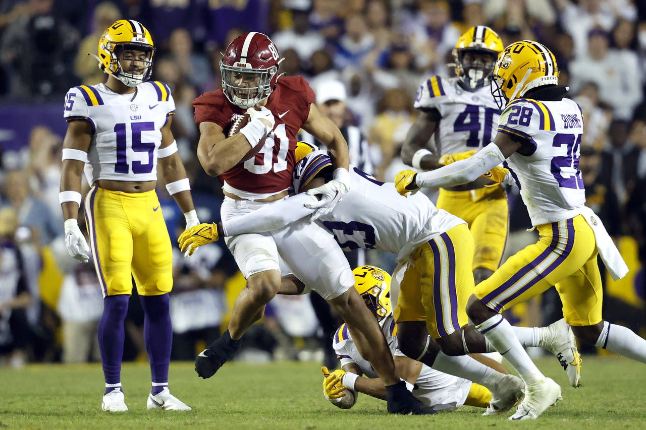 Alabama tight end Cameron Latu (81) is tackled by LSU linebacker Micah Baskerville (23) during the ...