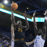 
              Long Beach State forward Lassina Traore (23) shoots next to UCLA forward Adem Bona (3) during the first half of an NCAA college basketball game Friday, Nov. 11, 2022, in Los Angeles. (AP Photo/Marcio Jose Sanchez)
            