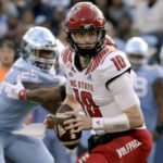 
              North Carolina State quarterback Ben Finley (10) looks to pitch as North Carolina defensive lineman Kaimon Rucker (25) rushes during the first half of an NCAA college football game Friday, Nov. 25, 2022, in Chapel Hill, N.C. (AP Photo/Chris Seward)
            