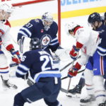 
              Winnipeg Jets goaltender Connor Hellebuyck (37) makes a save against a shot by Montreal Canadiens' Johnathan Kovacevic (26) during second-period NHL hockey game action in Winnipeg, Manitoba, Thursday, Nov. 3, 2022. (John Woods/The Canadian Press via AP)
            