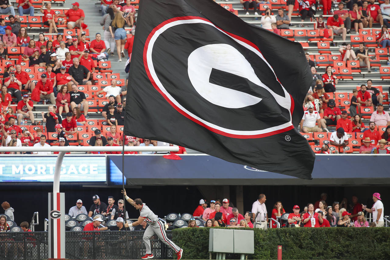 A Georgia cheerleader runs a flag across the end zone after a touchdown in the second half of an NC...