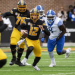 
              Missouri quarterback Brady Cook center, runs from Kentucky defensive tackle Octavious Oxendine, right, during the second quarter of an NCAA college football game Saturday, Nov. 5, 2022, in Columbia, Mo. (AP Photo/L.G. Patterson)
            